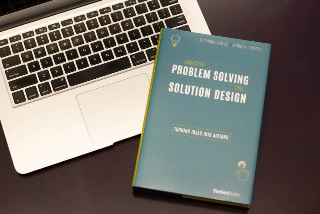 From Problem Solving to Solution Design by J. Eduardo Campos and Erica W. Campos, on a desk